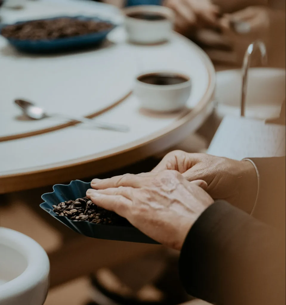 Hands holding a cup of coffee beans
